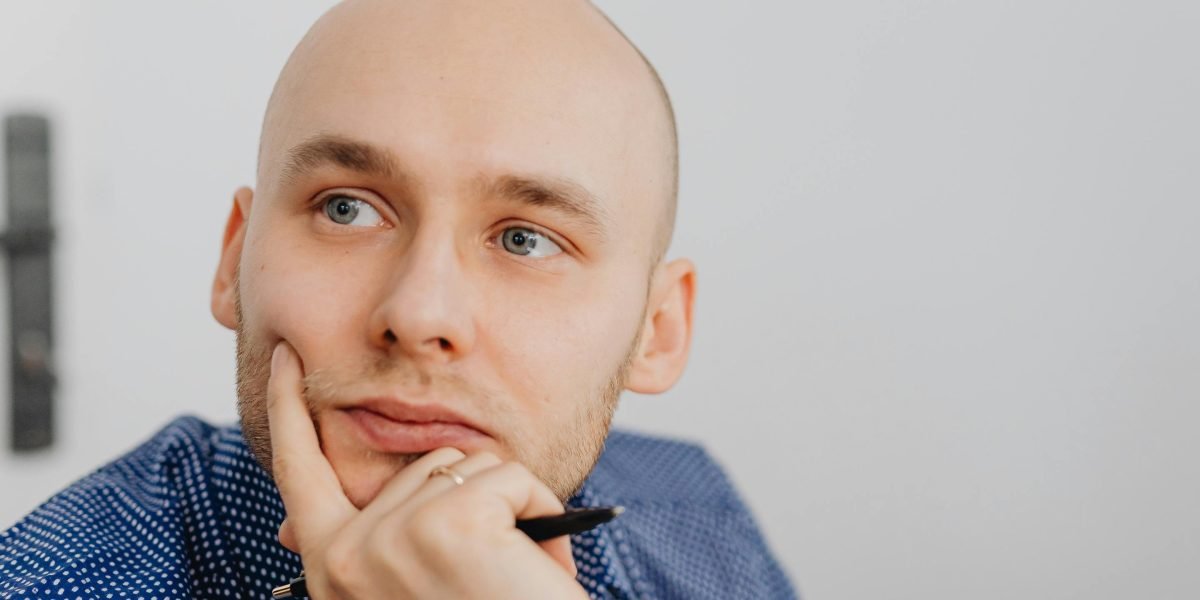 Osoba zamyślona, pracująca wieczorem, szukająca inspiracji do własnego biznesu e-commerce.