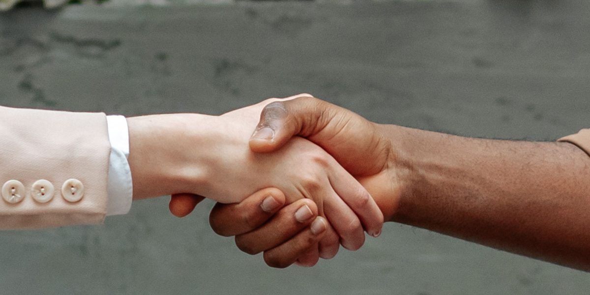 Two business professionals shaking hands, representing trust and successful partnership.